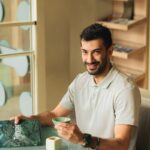 a man sitting at a table with a cup of coffee