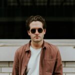 man standing in front of white concrete wall